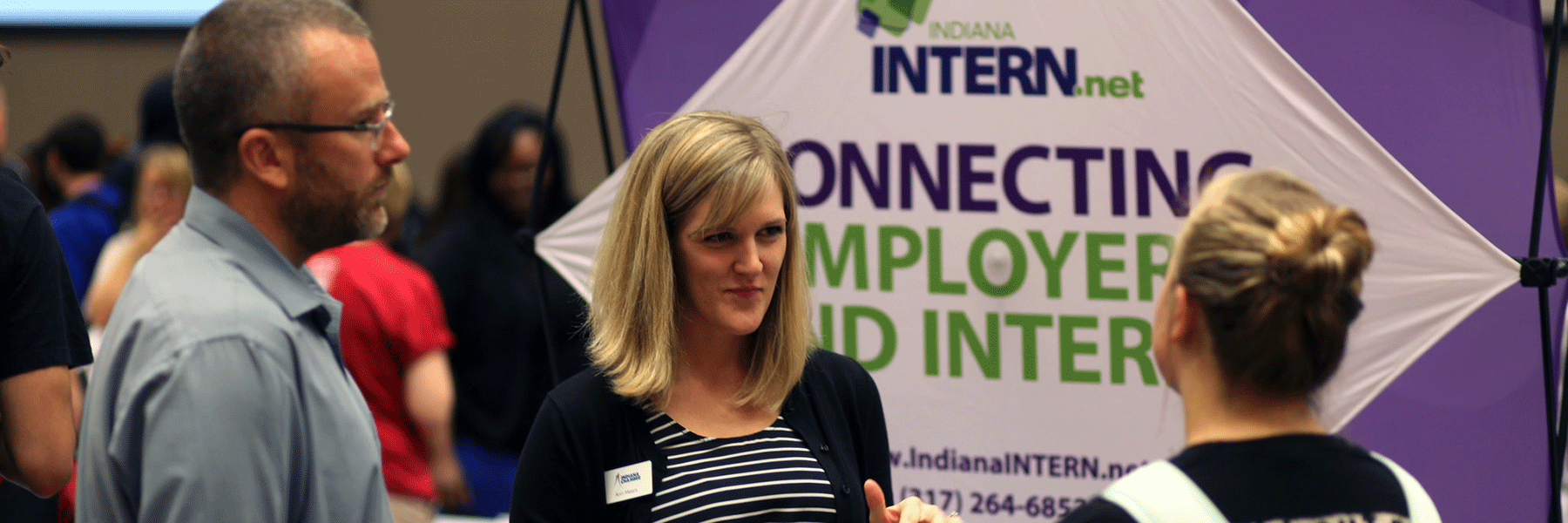 A photo of a student speaking with employers at a career event on campus.